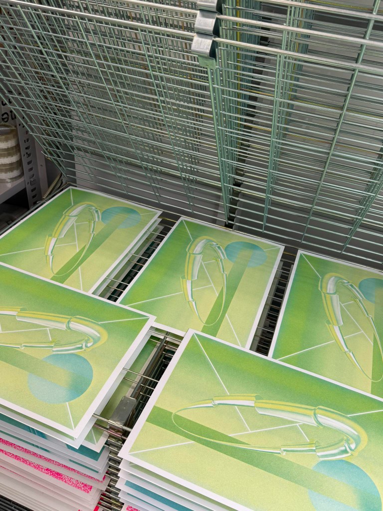 Green prints drying on a rack